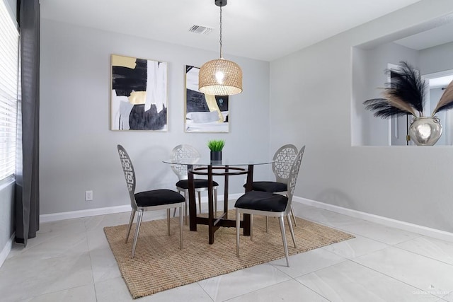 dining space with light tile patterned flooring, visible vents, and baseboards