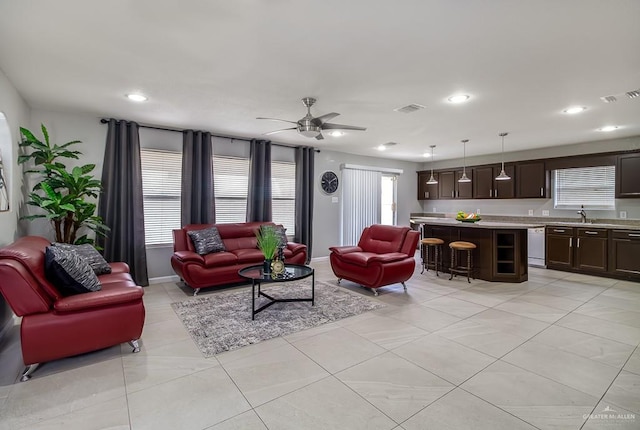 living area with ceiling fan, visible vents, and recessed lighting