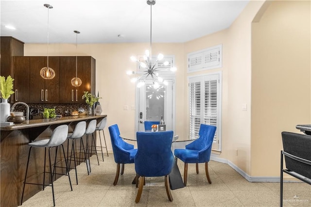 dining space featuring baseboards and a chandelier