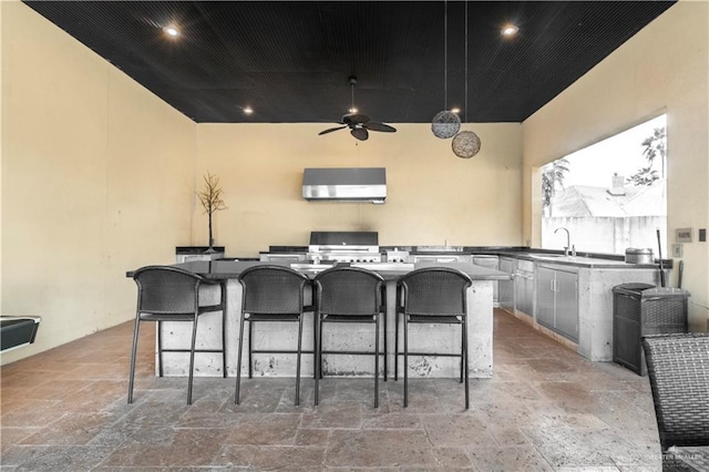 home theater featuring stone tile floors, ceiling fan, a sink, and recessed lighting