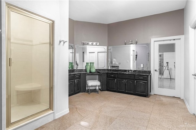 full bath with a stall shower, granite finish floor, vanity, and baseboards