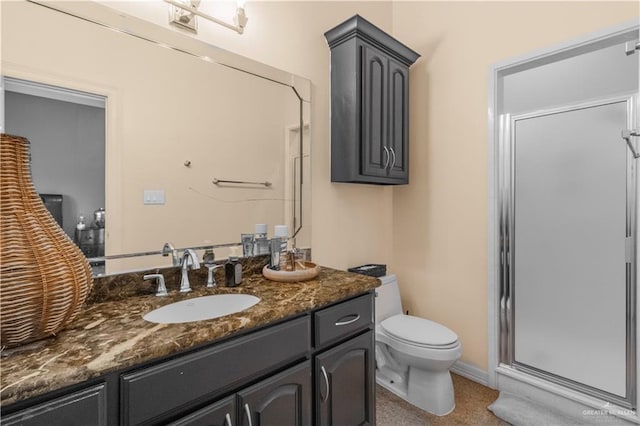 bathroom with baseboards, a shower stall, toilet, and vanity