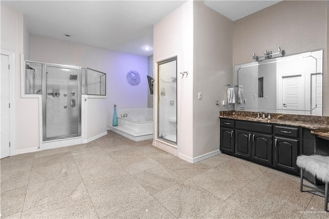 bathroom featuring a garden tub, a shower stall, baseboards, and vanity