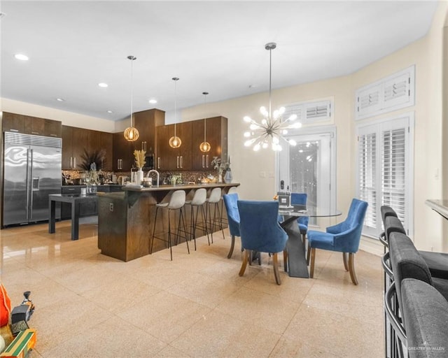 dining space featuring light speckled floor, recessed lighting, and an inviting chandelier