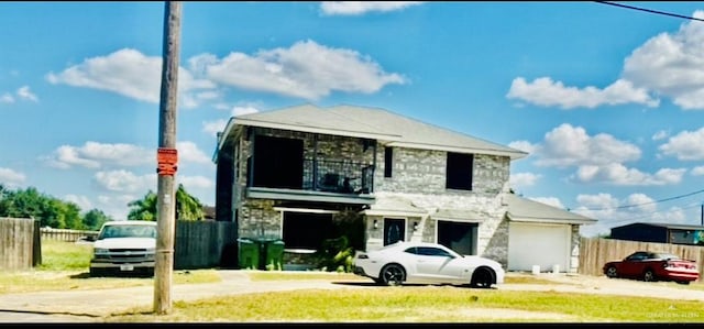 view of front facade featuring a garage and a balcony