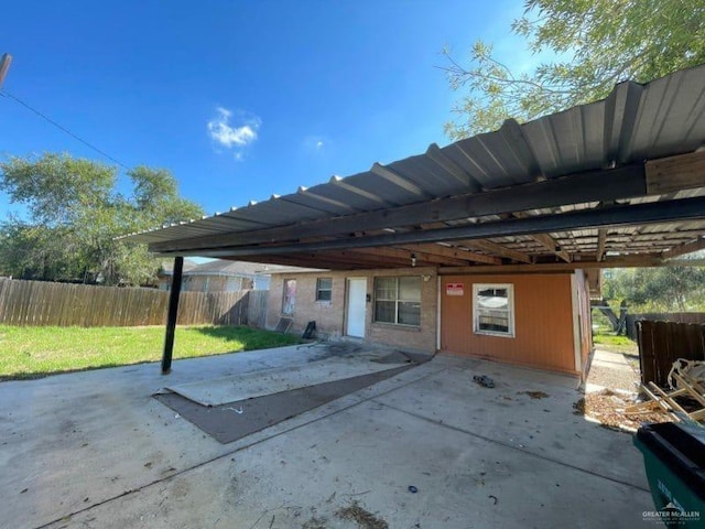 rear view of property with a carport and a yard