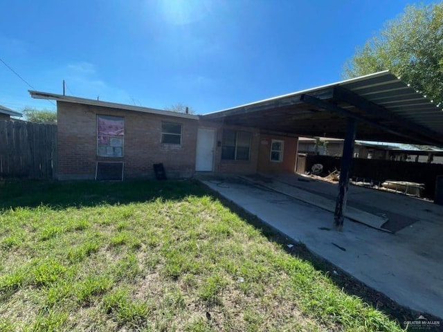 back of house featuring a lawn and a carport