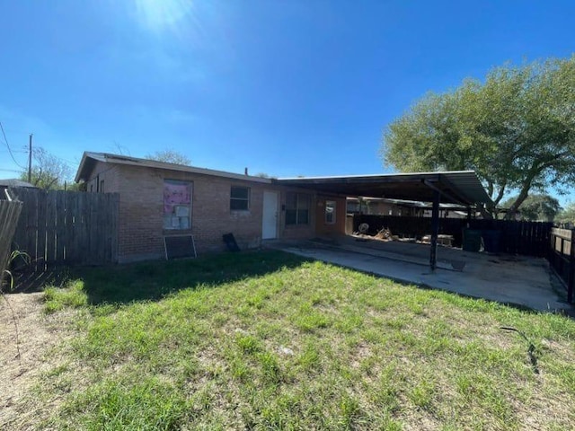 back of house featuring a carport and a yard