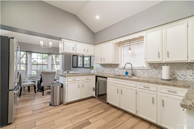 2105 Nightingale Ave W, Mcallen, TX 78504 - kitchen with a sink, stainless steel appliances, lofted ceiling, a peninsula, and backsplash