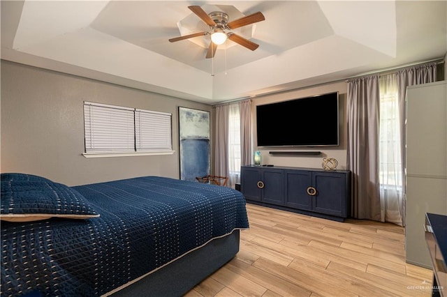 2105 Nightingale Ave W, Mcallen, TX 78504 - bedroom featuring a tray ceiling, light wood finished floors, multiple windows, and a ceiling fan