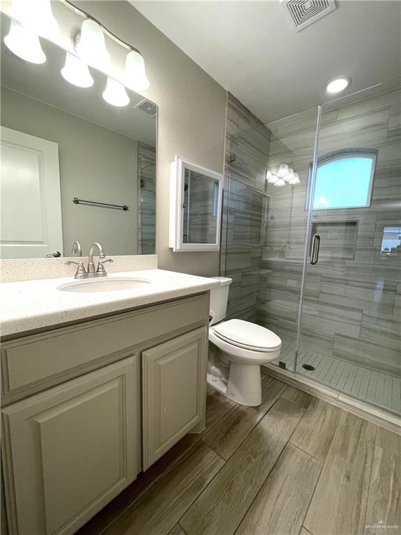 bathroom with vanity, toilet, and an enclosed shower