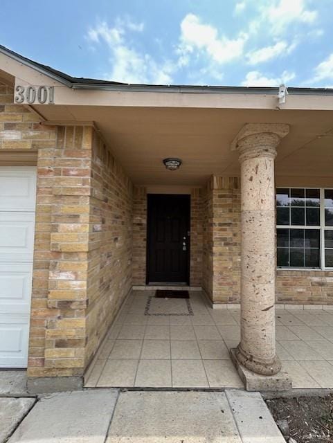 view of exterior entry featuring brick siding