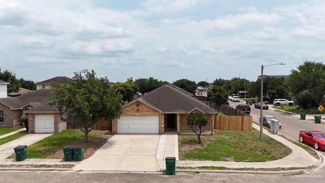 ranch-style home featuring fence, driveway, and a garage