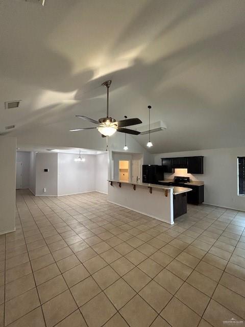 kitchen featuring light tile patterned floors, vaulted ceiling, and open floor plan