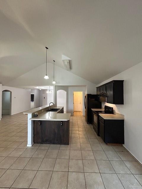 kitchen with electric range, a sink, light tile patterned floors, light countertops, and lofted ceiling