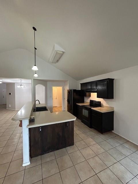 kitchen featuring light countertops, a sink, light tile patterned floors, black appliances, and vaulted ceiling