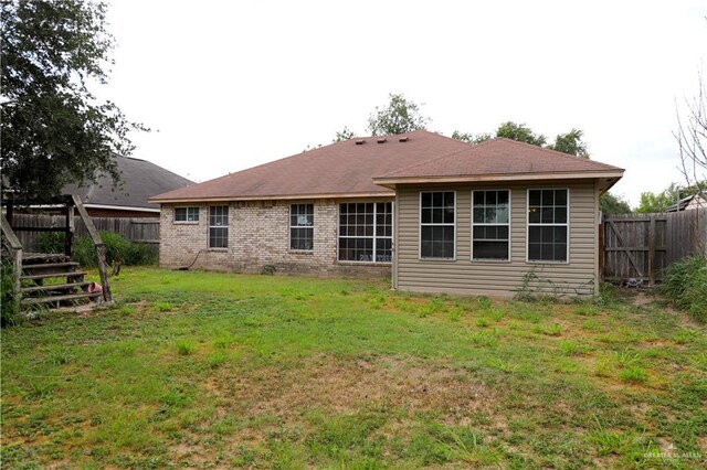 1811 Crown Pointe Blvd, Mission, TX 78572 - rear view of property with a fenced backyard, a lawn, and brick siding