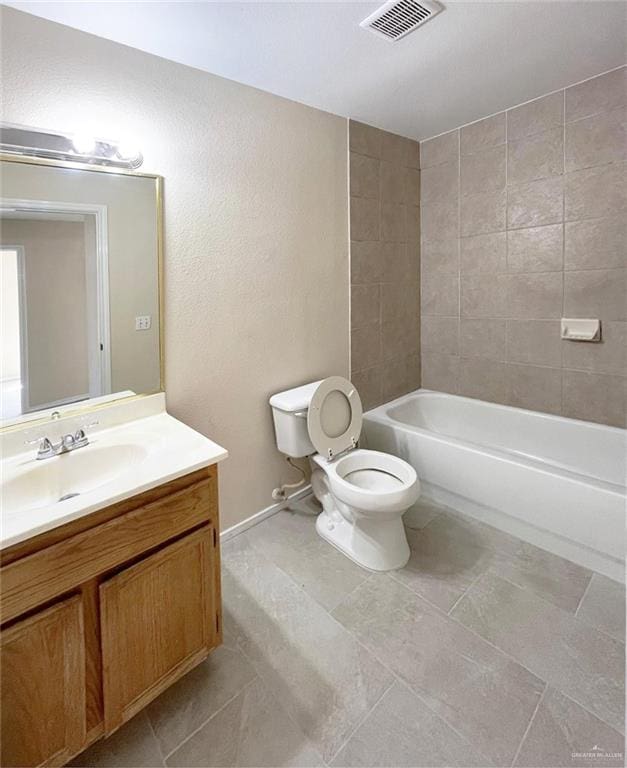 full bathroom with tile patterned floors, vanity, toilet, and tiled shower / bath combo