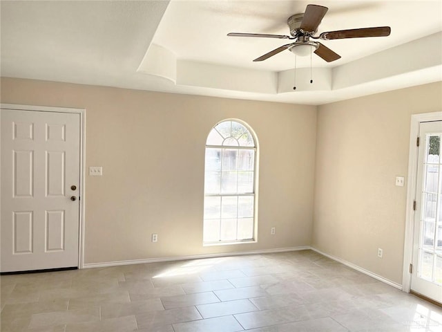 foyer entrance with ceiling fan and a tray ceiling