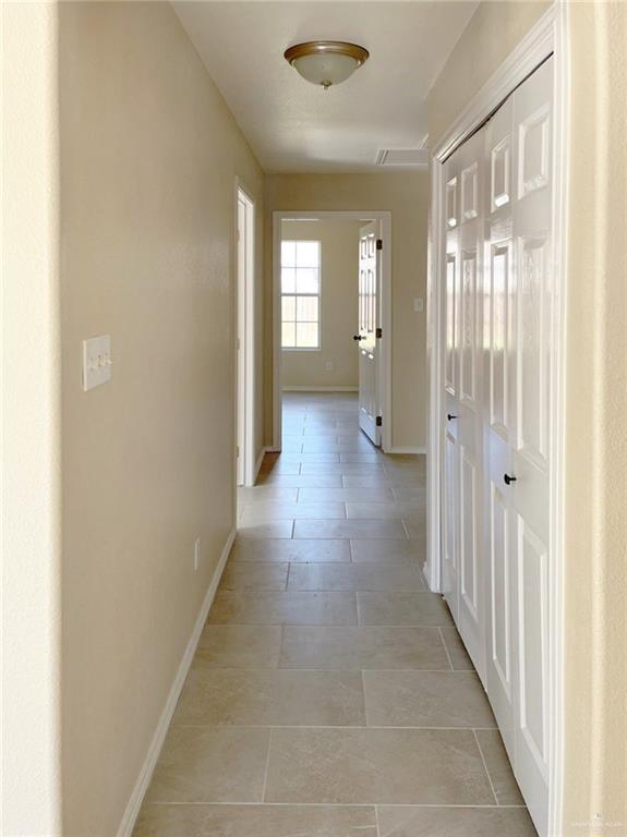 hall featuring light tile patterned floors