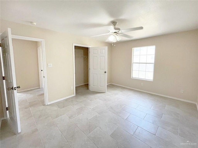 unfurnished bedroom featuring ceiling fan, a walk in closet, and a closet