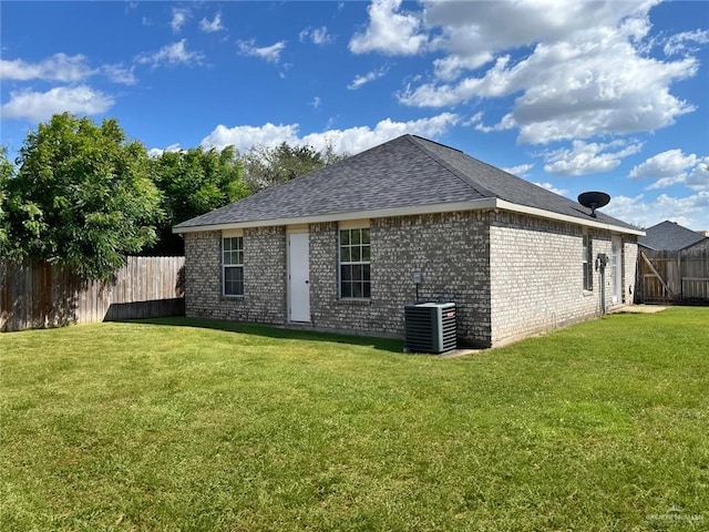 back of house featuring a lawn and cooling unit