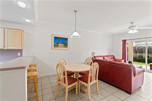 dining area featuring light tile patterned floors, ceiling fan, ornamental molding, and baseboards