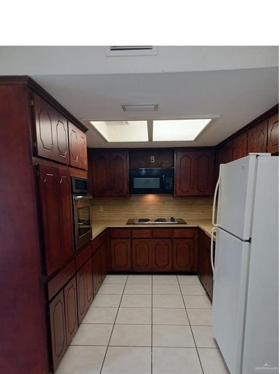 kitchen with white appliances, light tile patterned floors, and tasteful backsplash