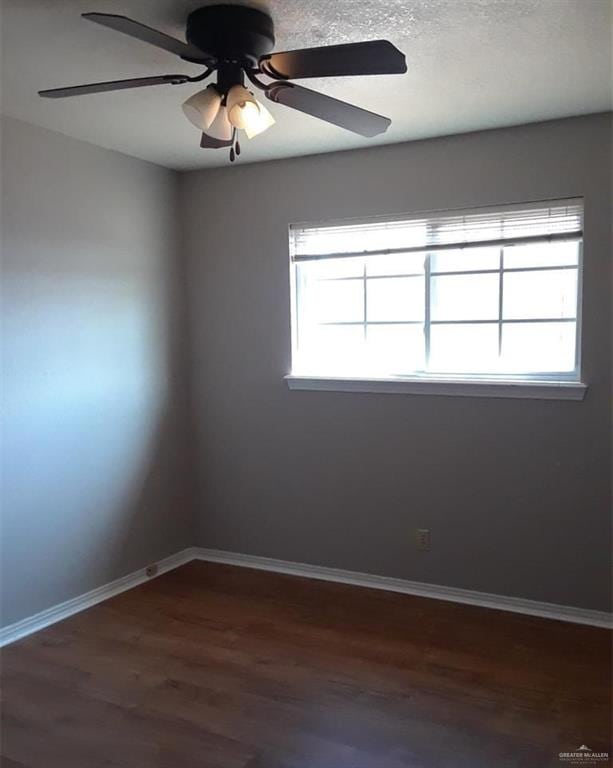 spare room featuring ceiling fan and dark hardwood / wood-style flooring