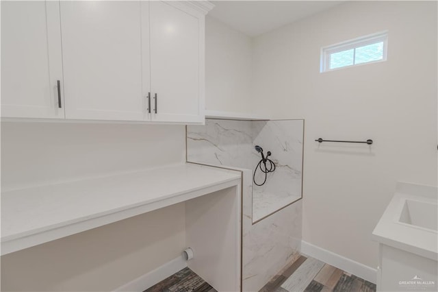 bathroom featuring baseboards, wood finished floors, and vanity
