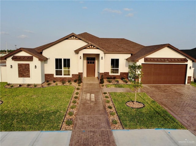view of front of property featuring a shingled roof, an attached garage, a front lawn, stucco siding, and driveway