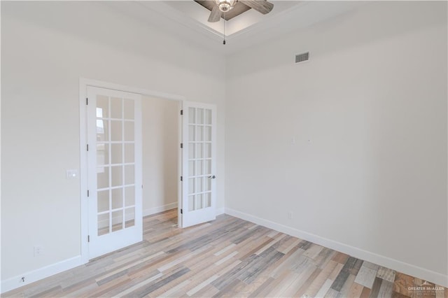 empty room with visible vents, baseboards, ceiling fan, french doors, and light wood-style flooring