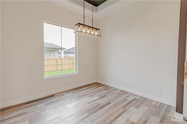 unfurnished dining area featuring baseboards, an inviting chandelier, and light wood-style flooring