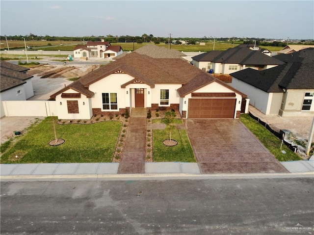 view of front of property featuring a front yard, stucco siding, a shingled roof, concrete driveway, and an attached garage