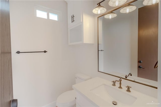 half bathroom featuring vanity and toilet