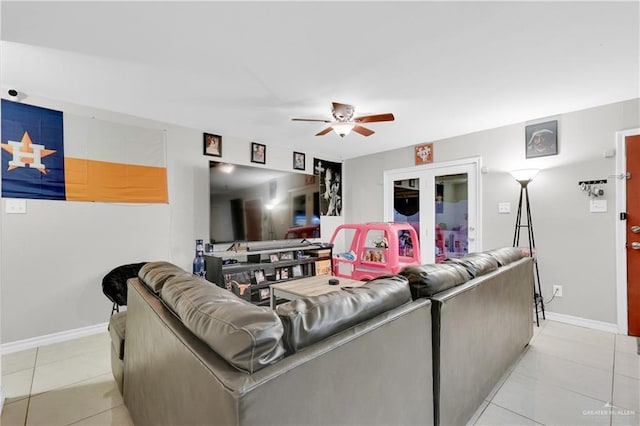 living room with light tile patterned floors, ceiling fan, and baseboards