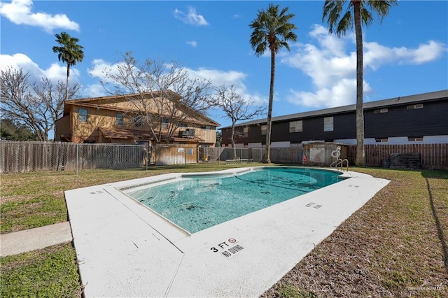 pool with a fenced backyard and a lawn