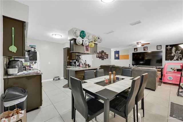 dining space with light tile patterned floors, ceiling fan, visible vents, and baseboards