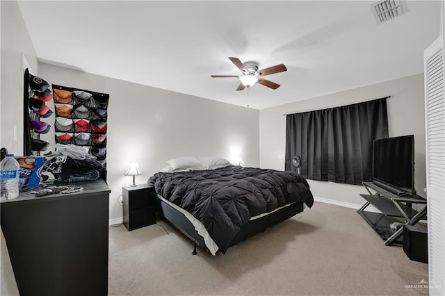 bedroom featuring baseboards, visible vents, a ceiling fan, and light colored carpet