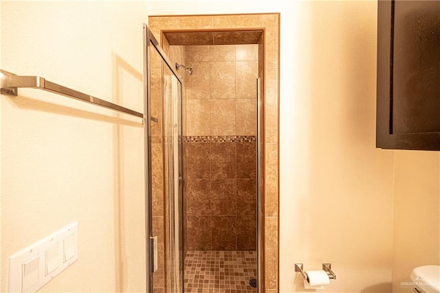 bathroom with toilet and a shower with shower door