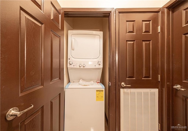 clothes washing area with stacked washing maching and dryer