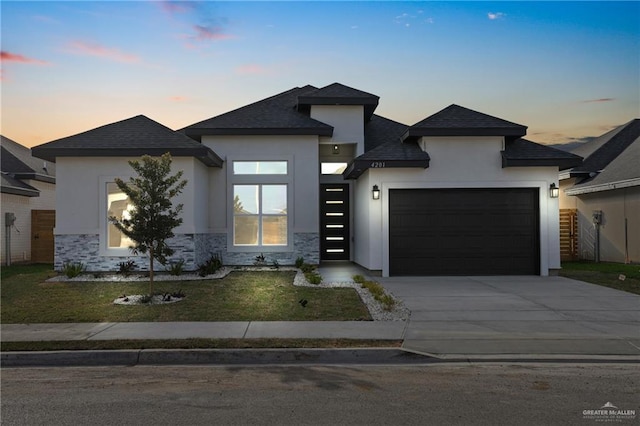 view of front of home with a garage, concrete driveway, stone siding, and stucco siding