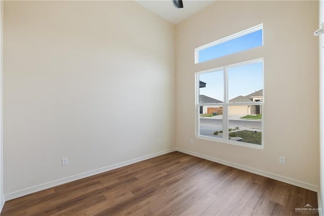 empty room with baseboards and wood finished floors