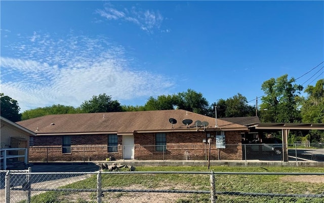 ranch-style house with brick siding, a fenced front yard, and a carport