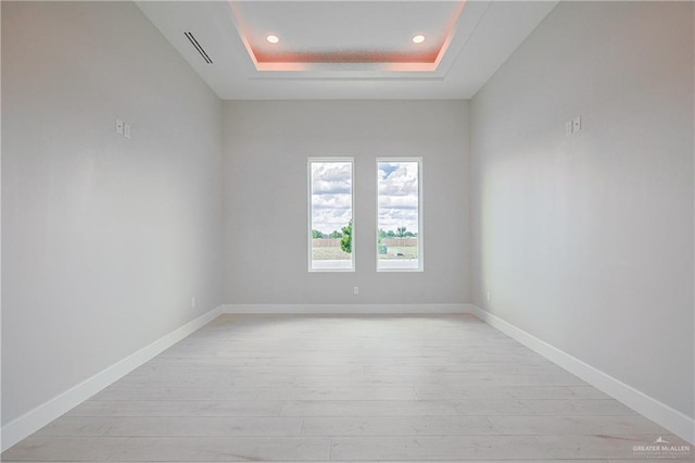 8047 N 48th Ln, Mcallen, TX 78501 - empty room with light wood-type flooring, a tray ceiling, and recessed lighting