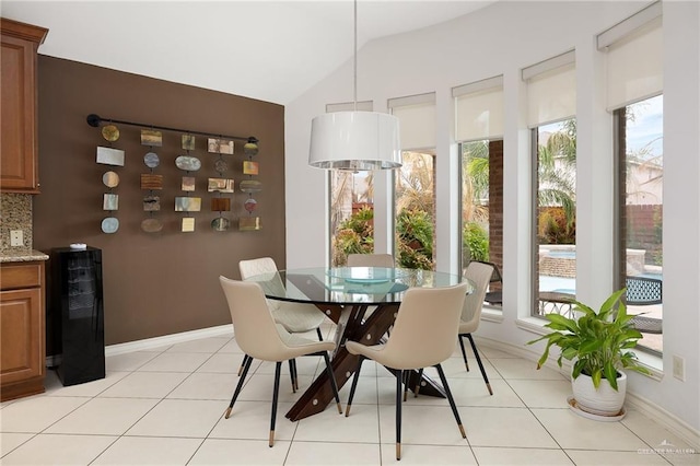 dining area with wine cooler, vaulted ceiling, and light tile patterned floors