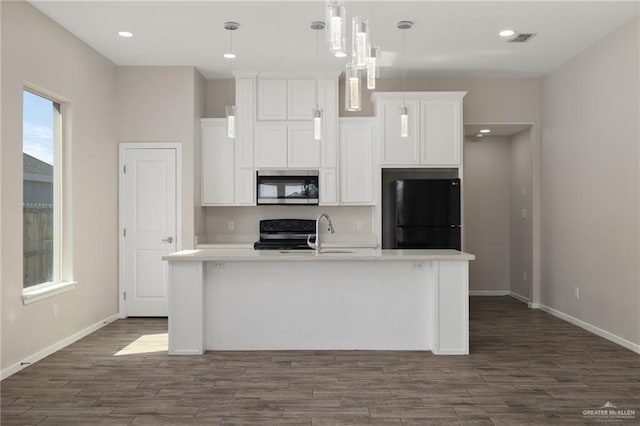 kitchen with sink, an island with sink, pendant lighting, white cabinets, and black appliances