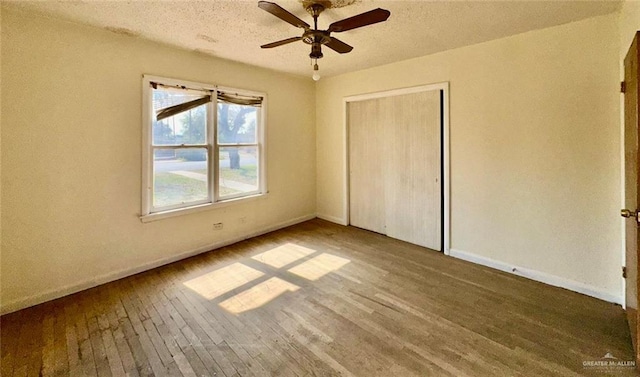 unfurnished bedroom with wood-type flooring, a textured ceiling, and a closet