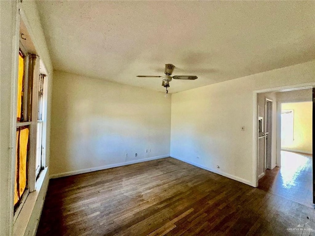 empty room featuring a textured ceiling, dark wood-type flooring, and ceiling fan