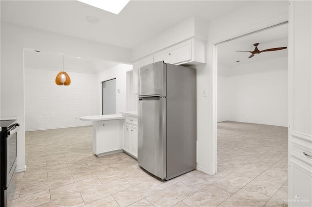 kitchen featuring hanging light fixtures, appliances with stainless steel finishes, white cabinetry, and ceiling fan